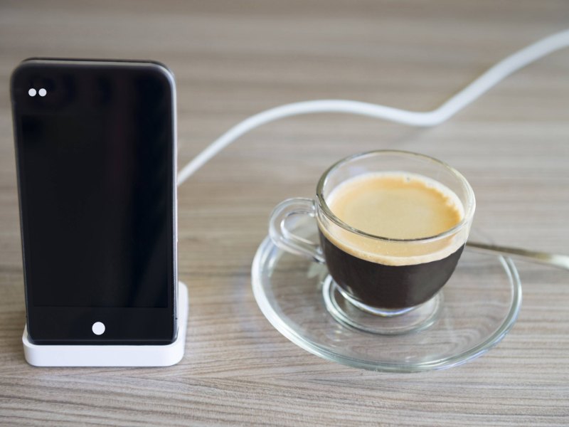 iPhone an Ladestation neben Kaffee