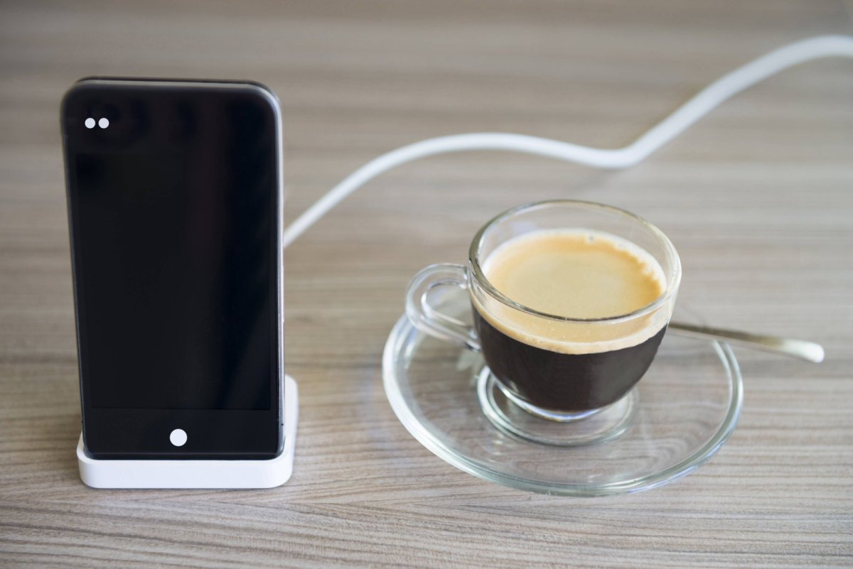 iPhone an Ladestation neben Kaffee