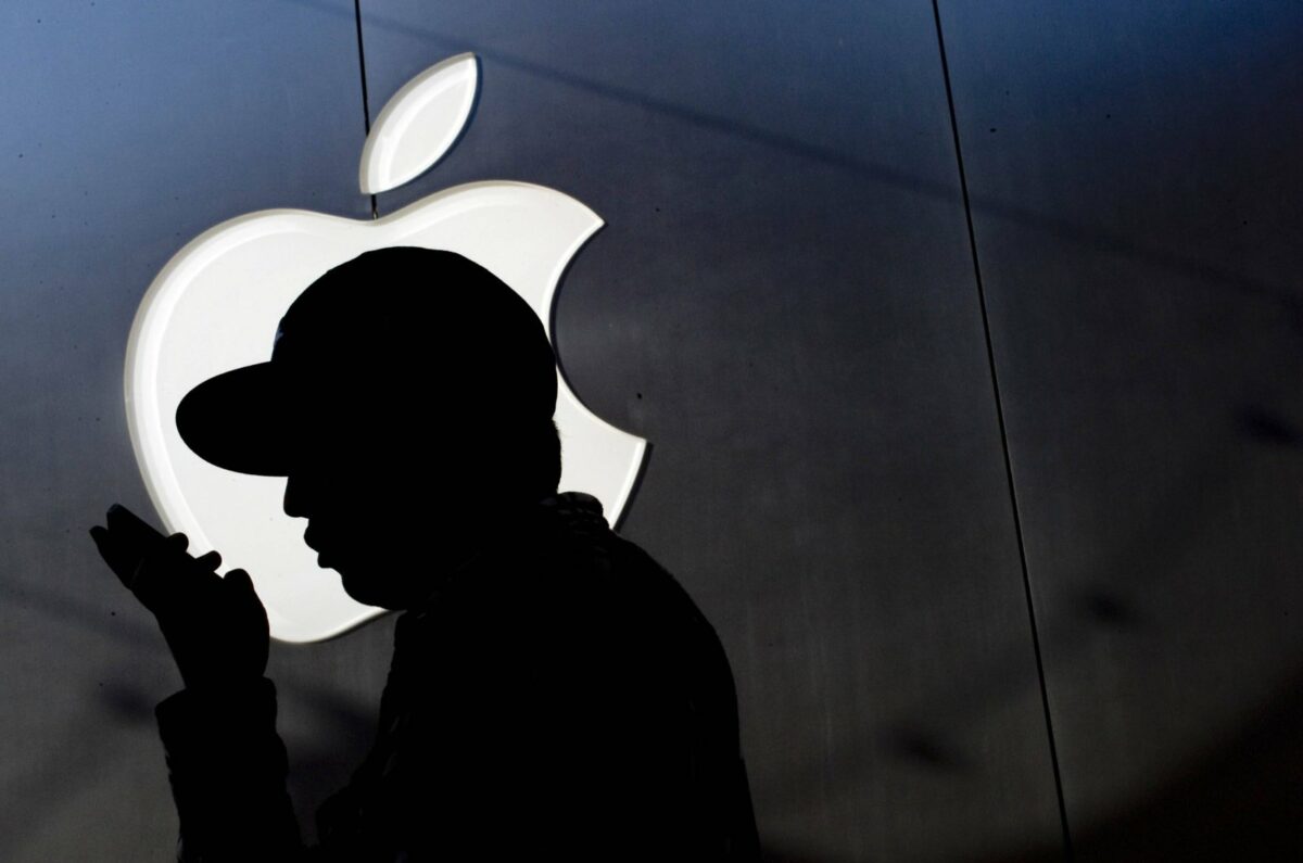 Silhouette von Mann mit iPhone vor Apple Logo.