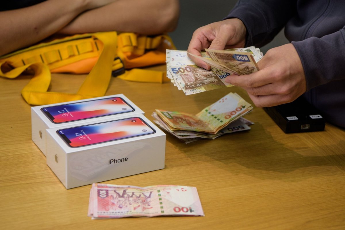 Person legt Geld für ein iPhone auf den Tisch