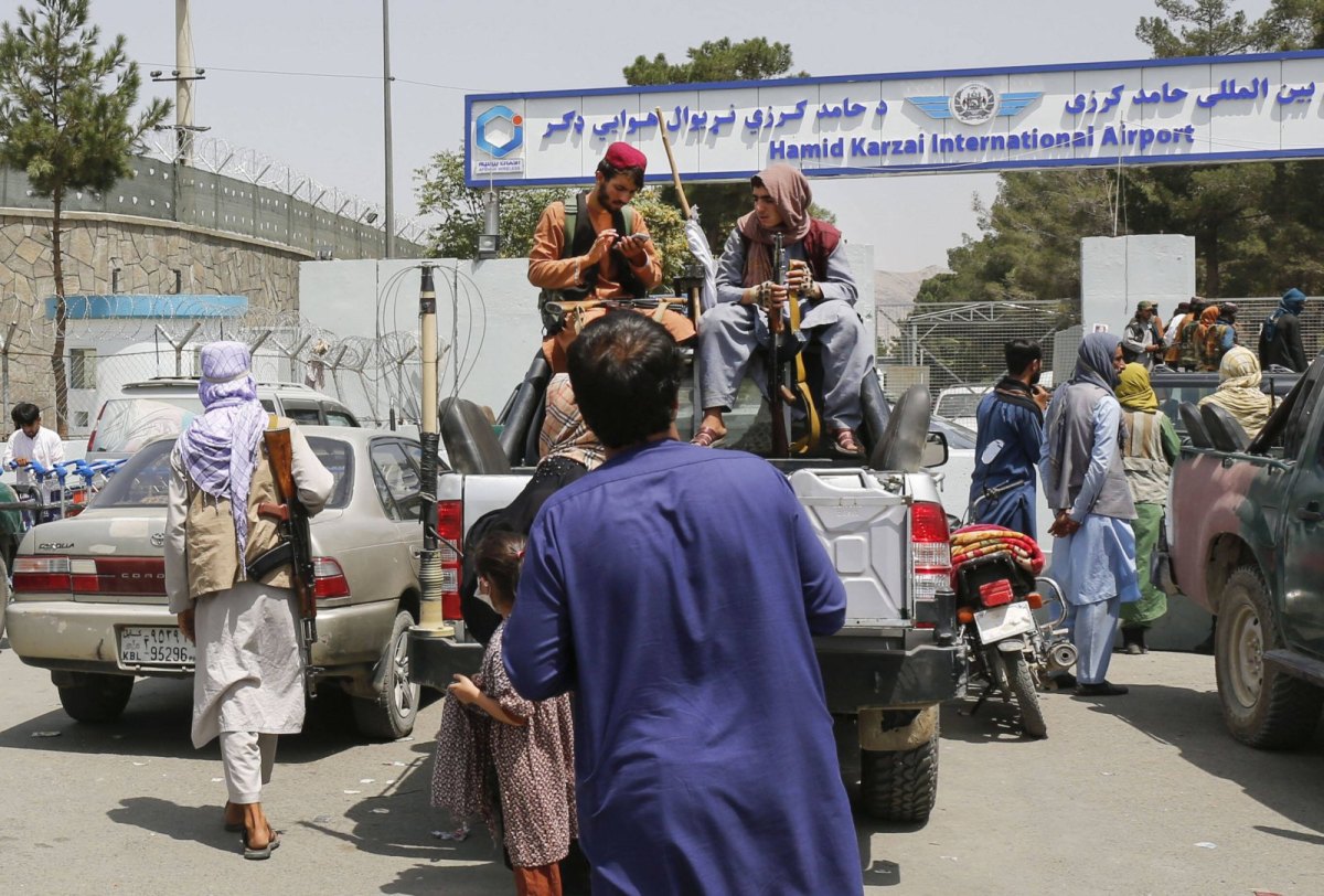 Männer mit Waffen sitzen auf einem Auto vor einem Flughafen in Kabul am 17. August 2021.