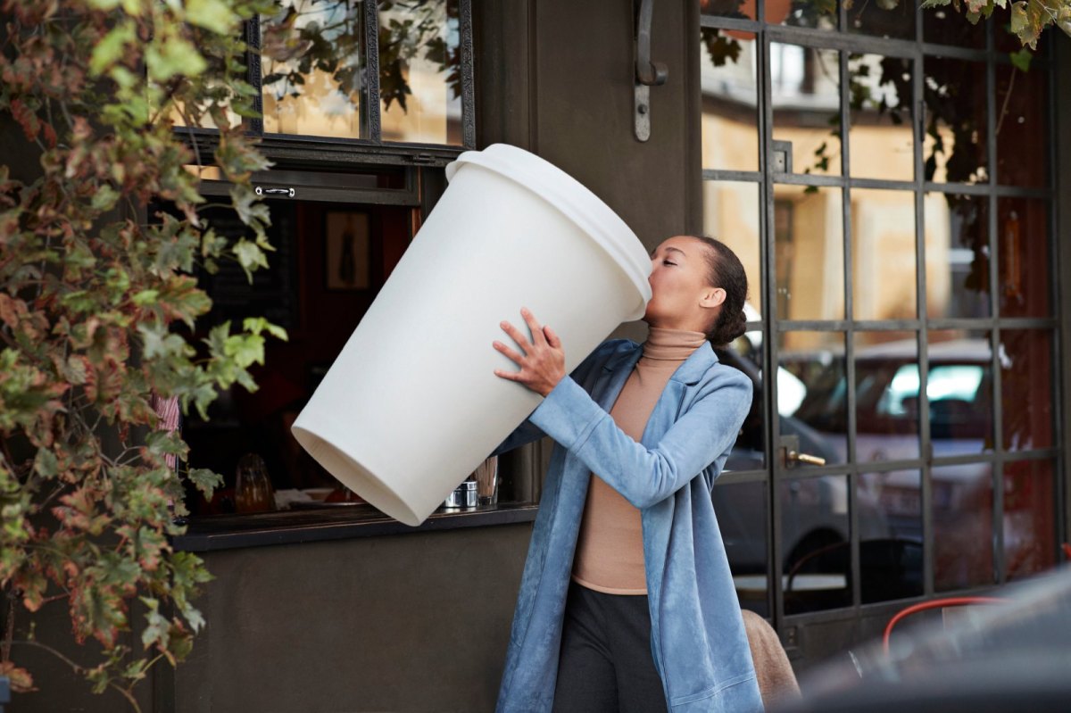 Frau mit übergroßem Kaffeebecher