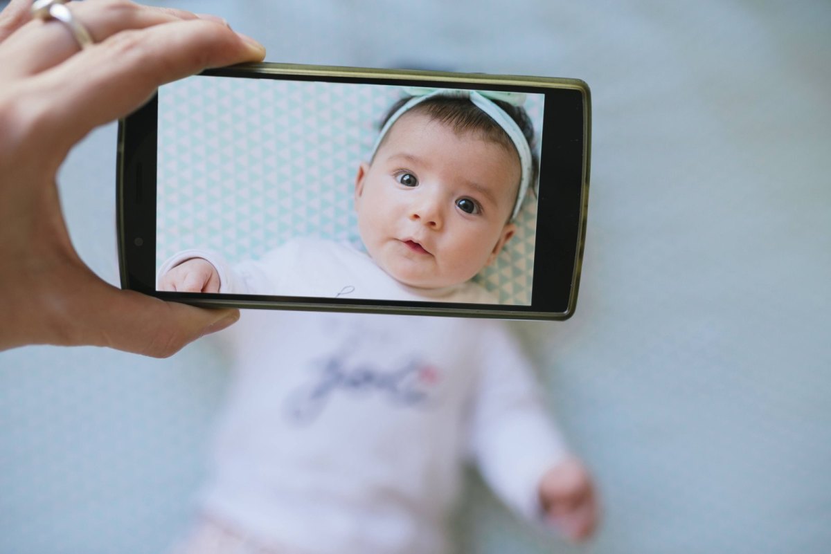 Ein Baby wird mit einem Smartphone fotografiert.