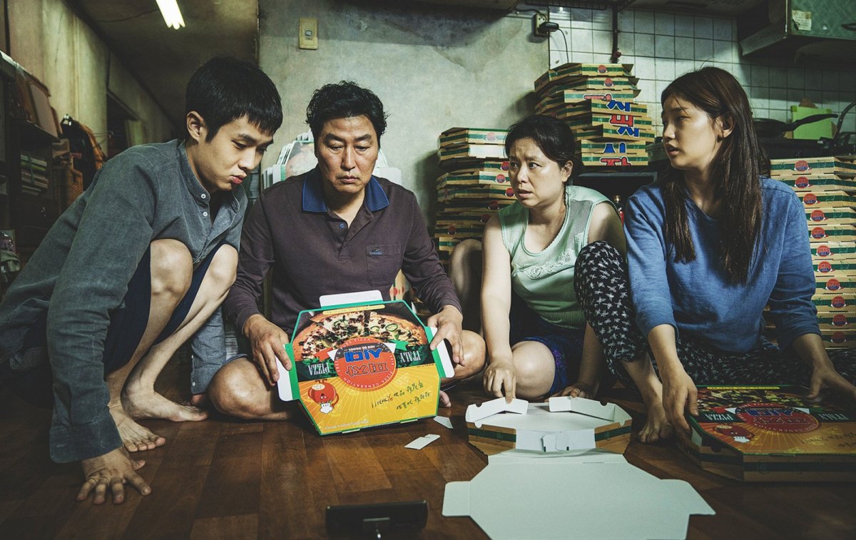 Szenenbild aus Parasite: Die ganze Familie Kim faltet Pizza-Schachteln