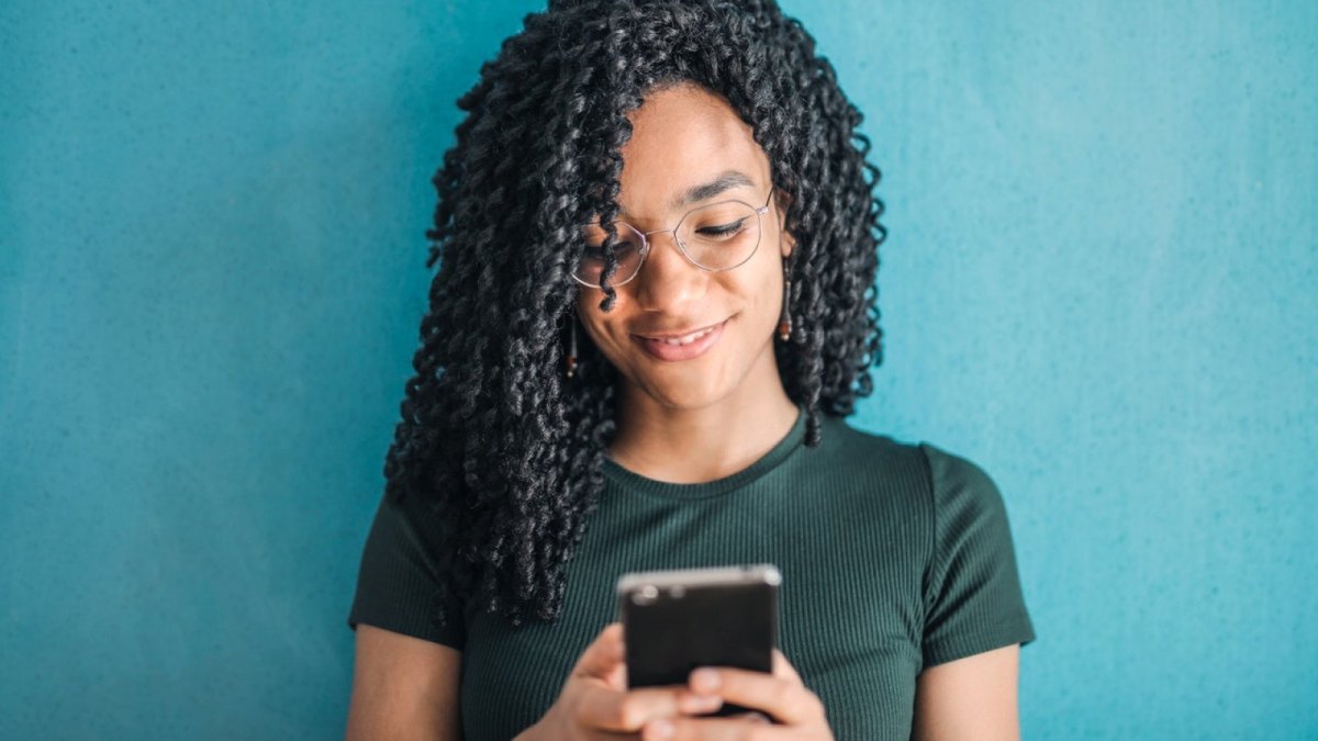 Eine Frau mit einem Smartphone in der Hand.