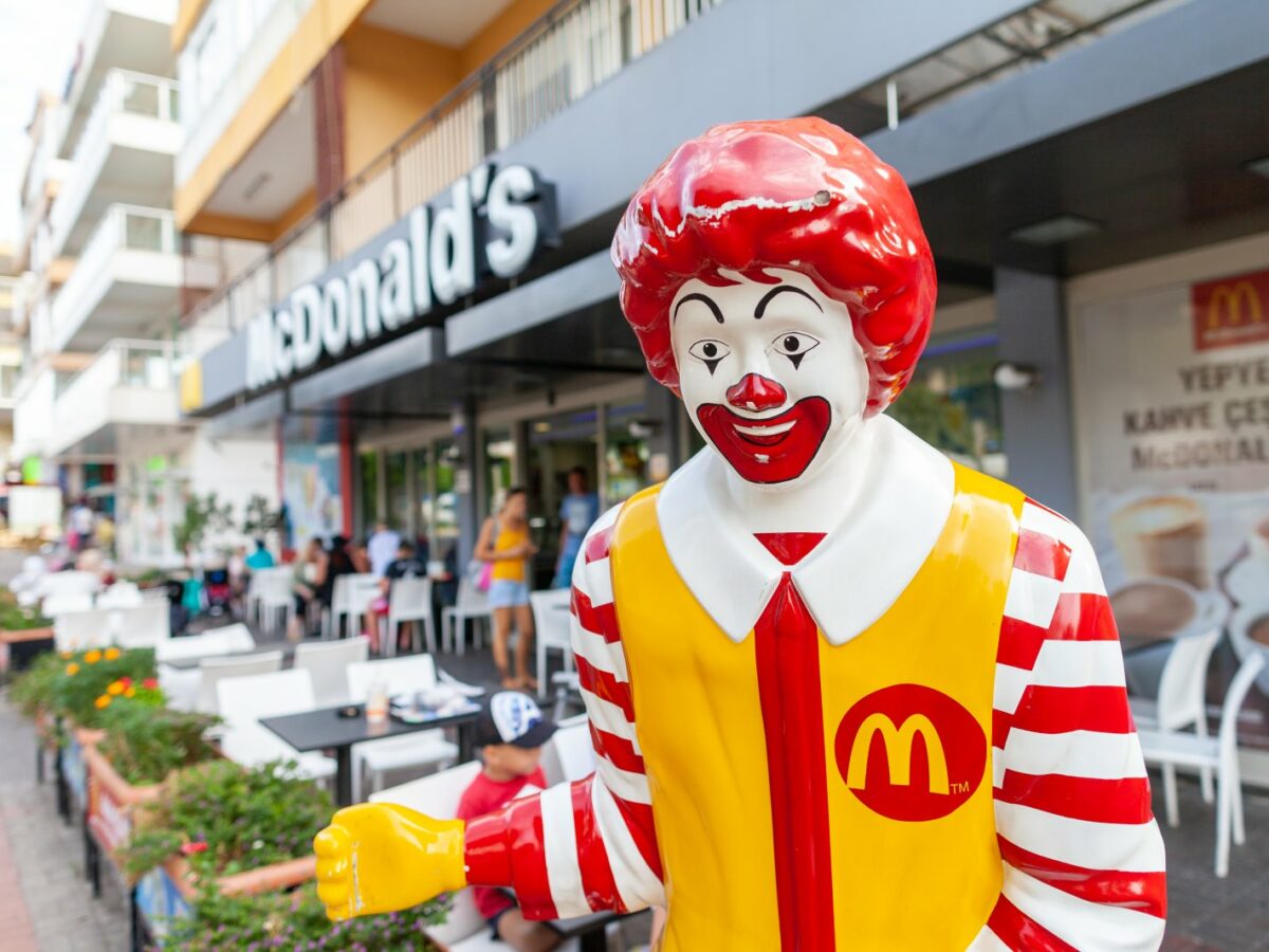 Eine Ronald McDonald-Figur vor einem McDonalds-Restaurant.