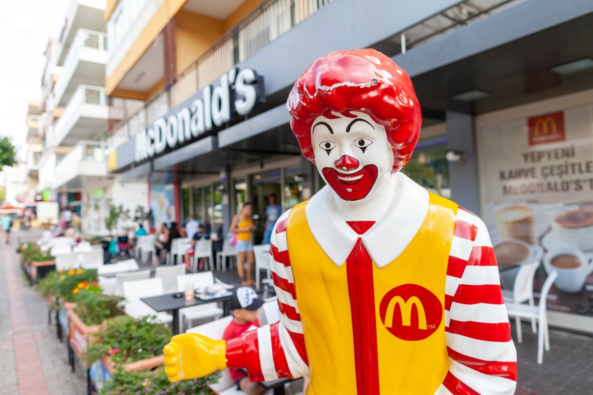 Eine Ronald McDonald-Figur vor einem McDonalds-Restaurant.