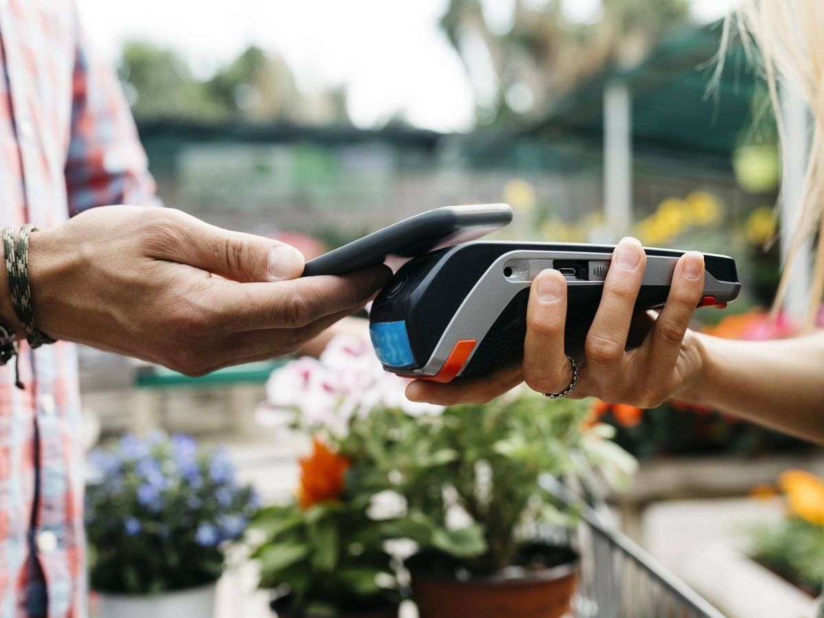 Ein Kunde zahlt auf dem Wochenmarkt mit seinem Smartphone