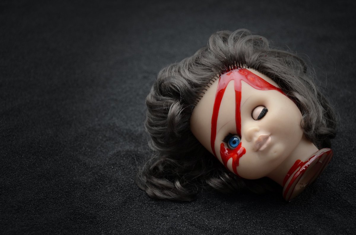 Kopf einer Puppe mit roten Flecken.