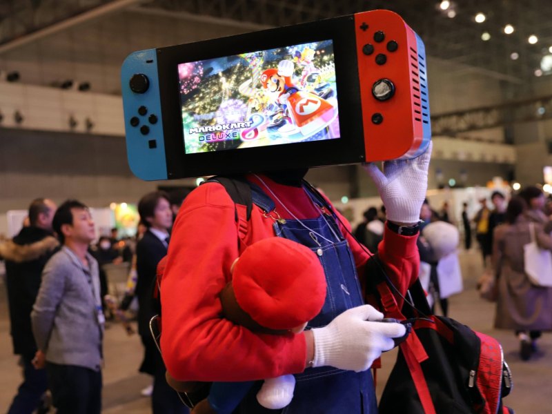 Ein Mann trägt eine Nintendo Switch auf seinem Kopf