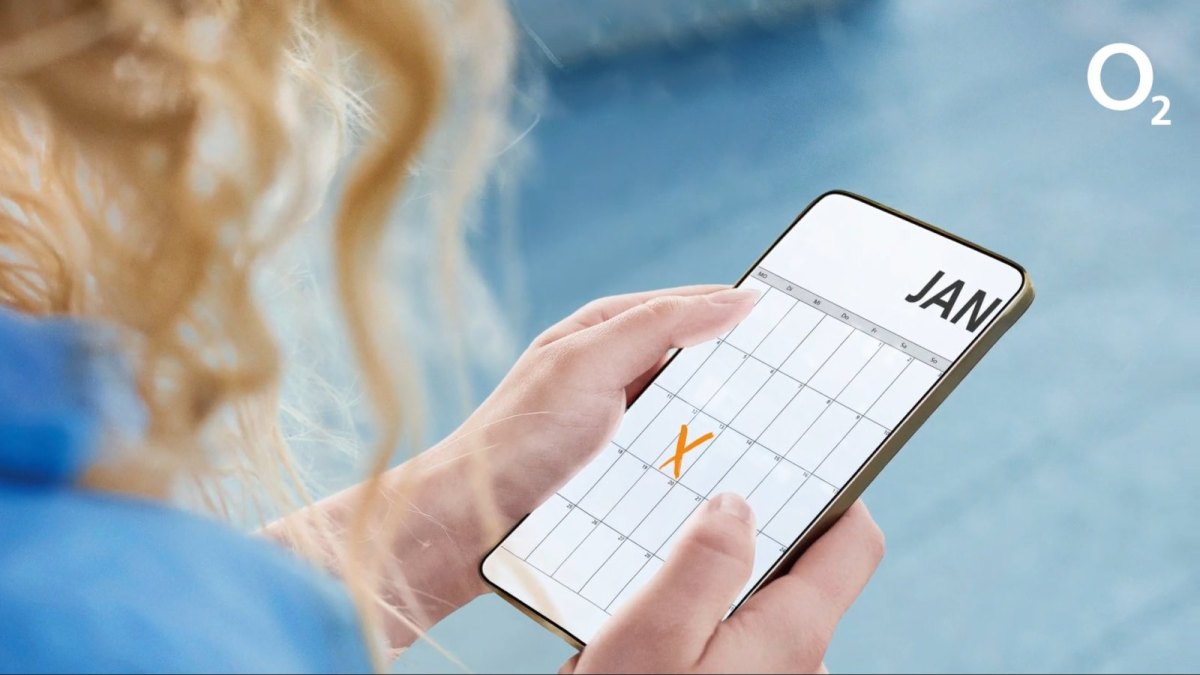 Frau hält Smartphone mit Kalender und X darauf