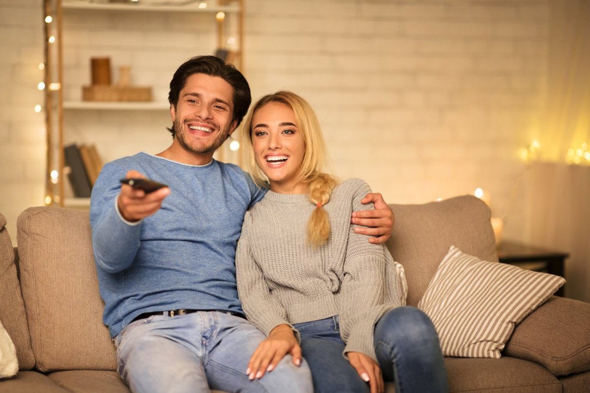 Ein Prächen sitzt vor dem Fernseher.