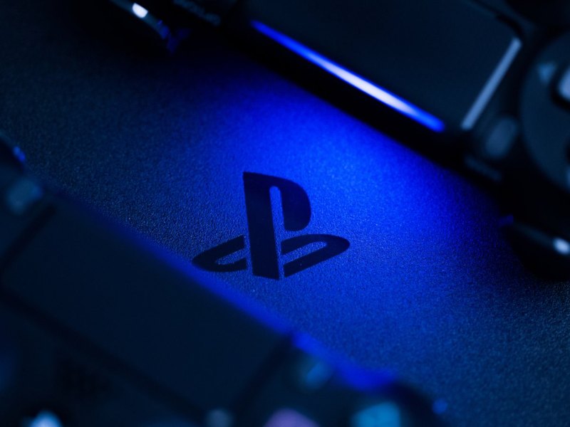 Zwei DualShock 4-Controller rahmen das PlayStation-Logo ein