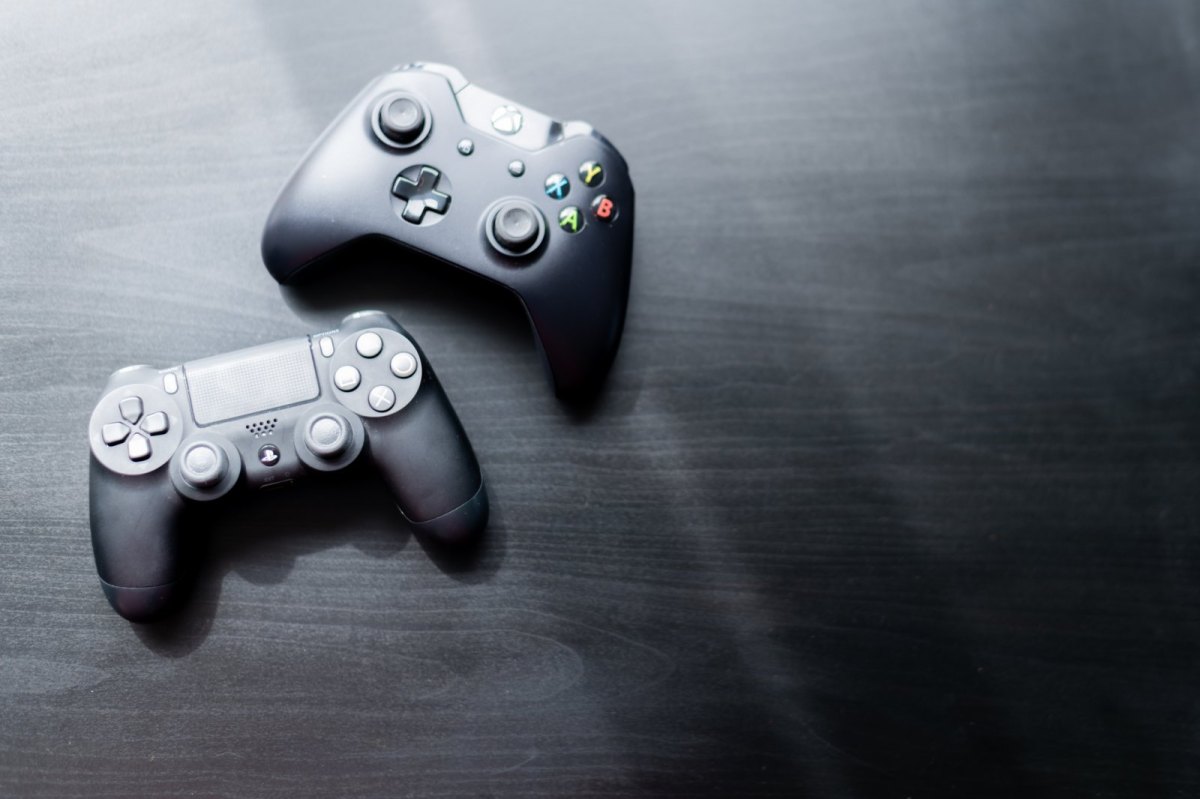 PlayStation- und Xbox-Controller auf grauem Holz