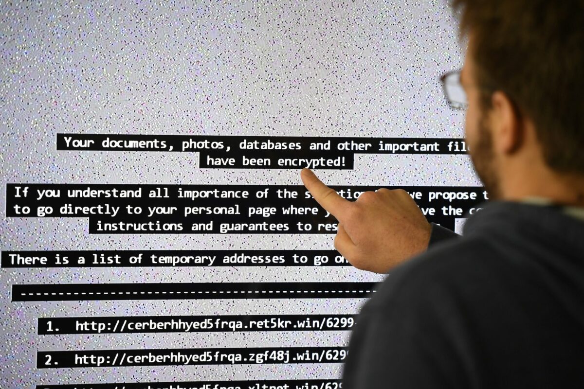 Mann vor Computerbildschirm mit erpresserischer Nachricht