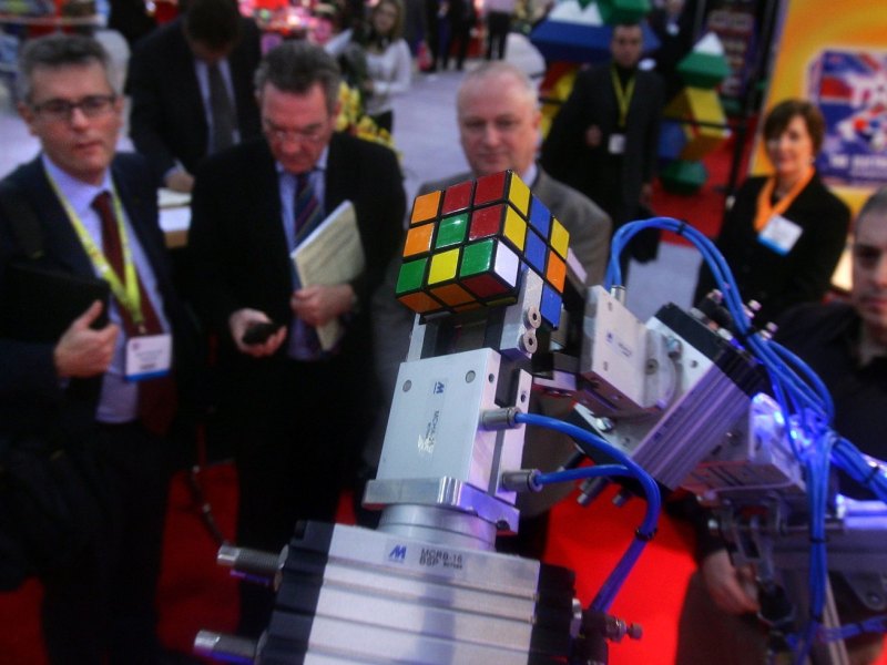 Roboter hält Rubikwürfel zwischen seinen Armen