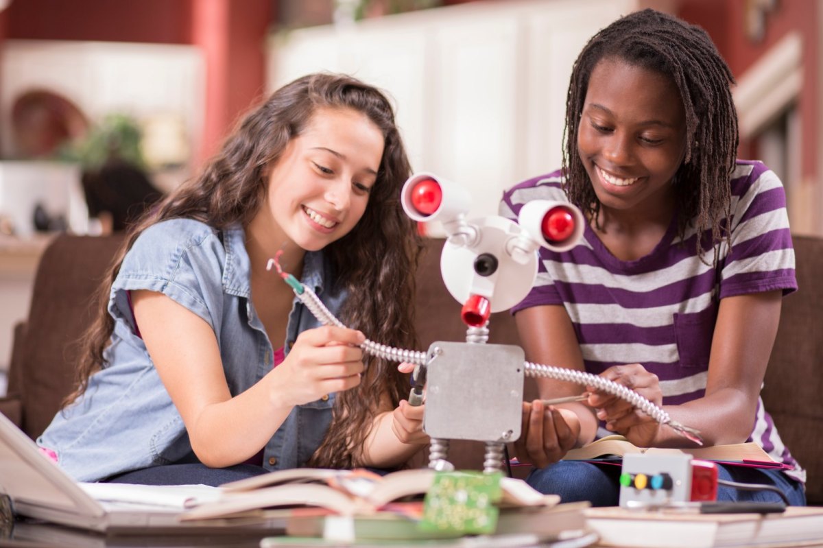 Zwei junge Frauen bauen einen Roboter.