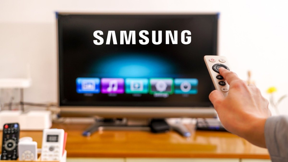 Eine Fernbedienung zeigt auf einen Fernseher mit Samsung-Logo.