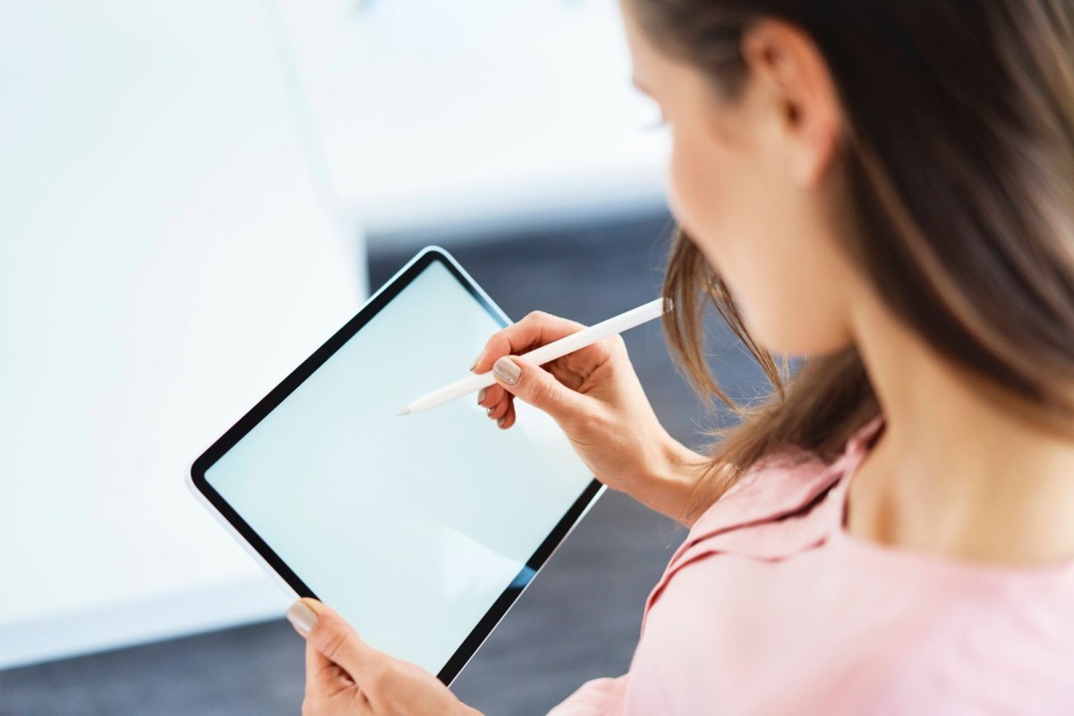 Frau schreibt auf einem Tablet.