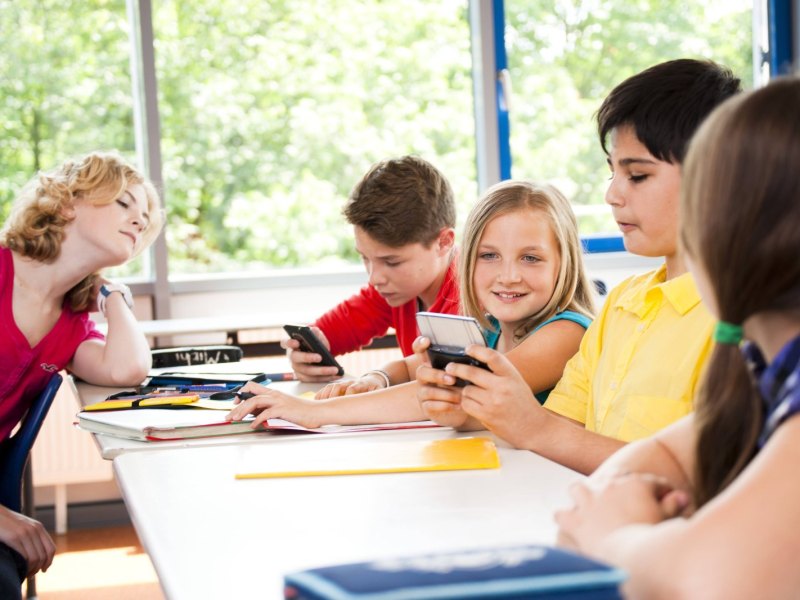 Schüler benutzen Smartphones im Unterricht