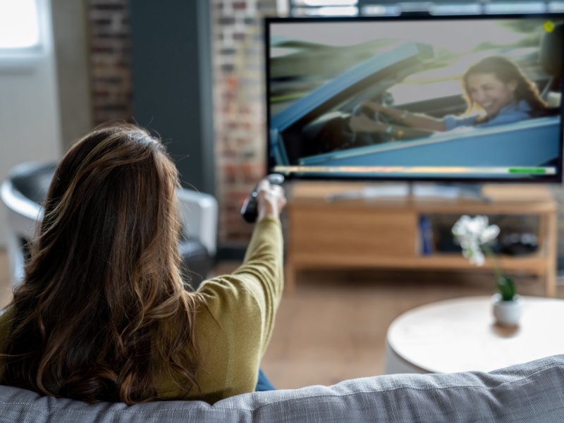 Frau sitzt vor dem Fernseher.