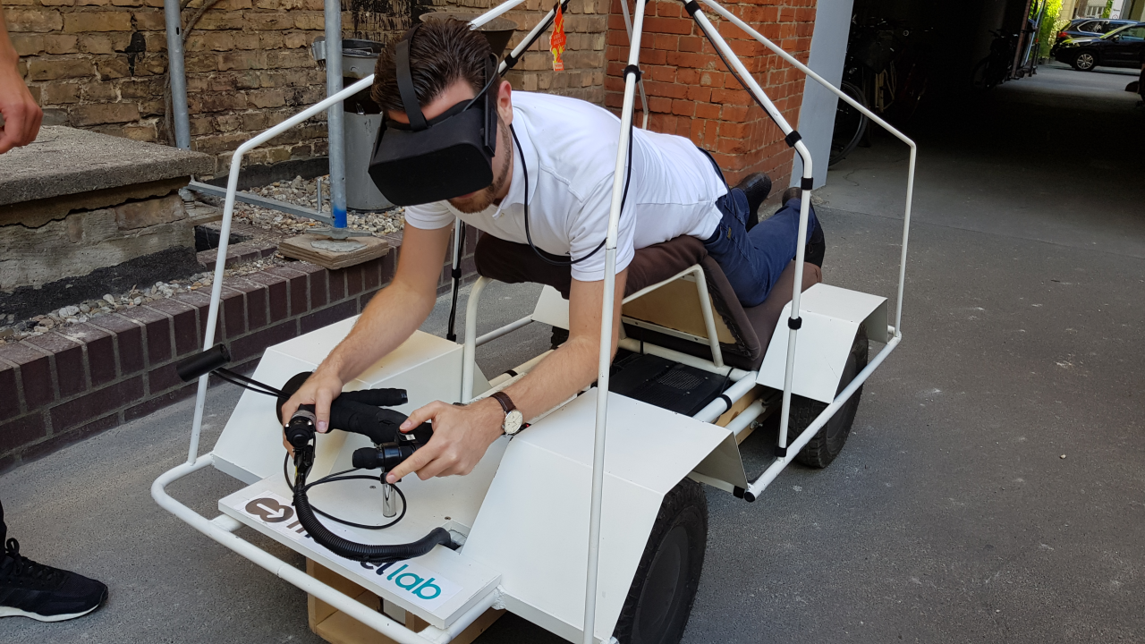 Die Position auf dem self-driving car ist zunächst ungewohnt, funktioniert aber wunderbar, da sich alle wichtigen Informationen auf dem Screen des VR-Headset abspielen