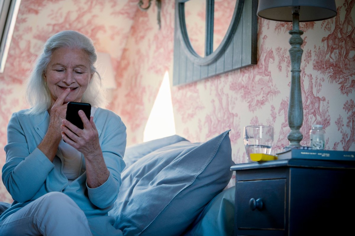 Alte Frau mit Handy lacht