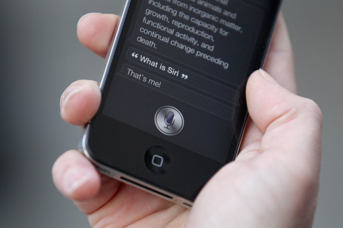 Hand hält iPhone mit Siri in der Hand