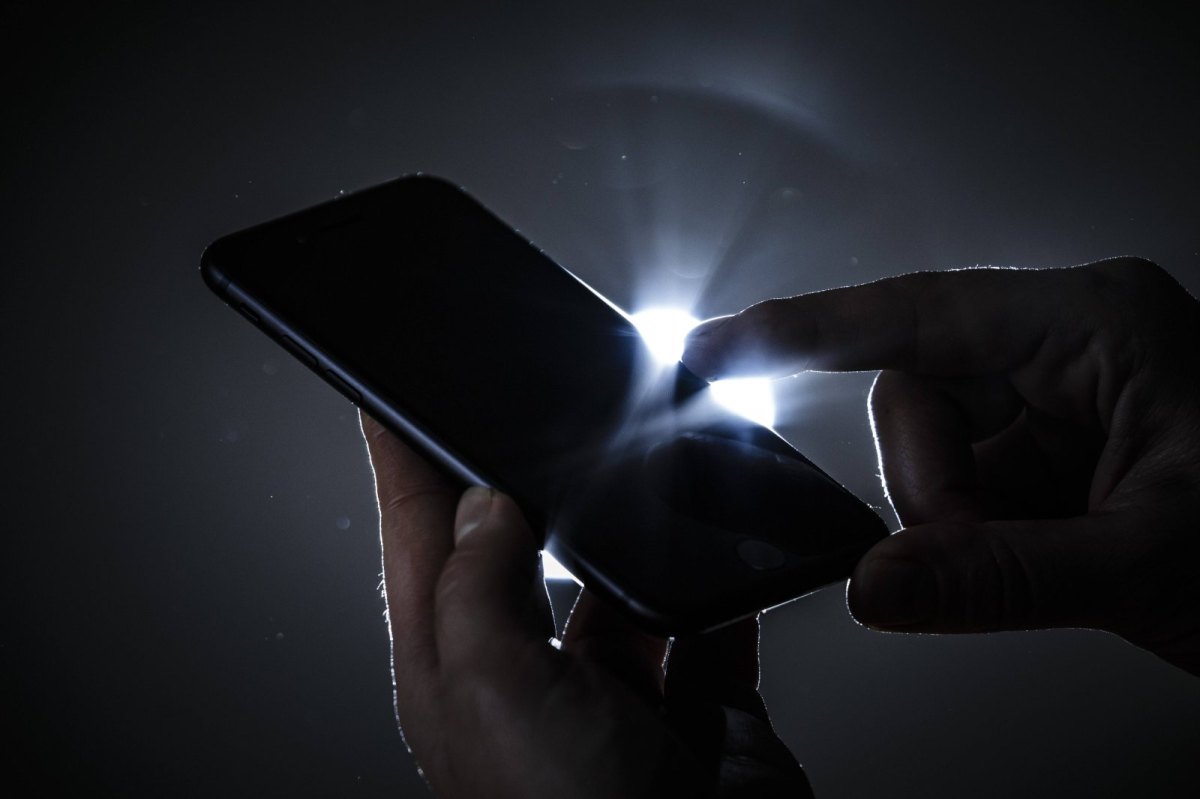 Smartphone vor Gegenlicht im Dunkeln