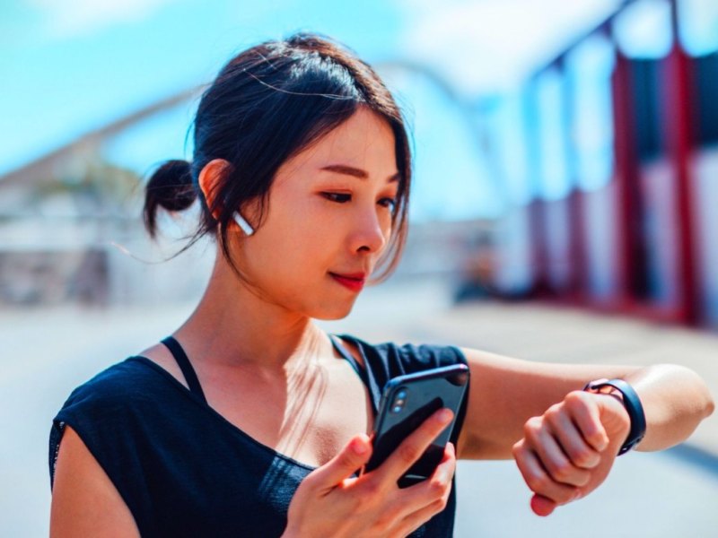 Frau mit Smartwatch und Kopfhörern