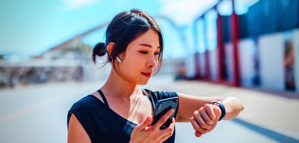 Frau mit Smartwatch und Kopfhörern