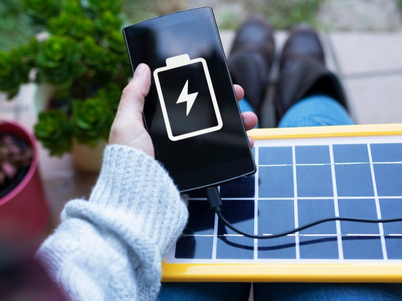 Handy wird mit Solar-Panel aufgeladen.