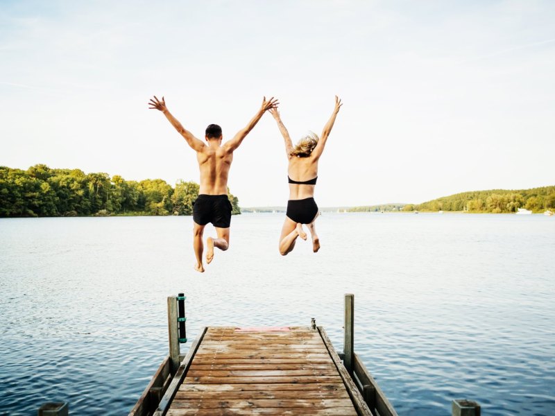 Mann und Frau springen in See.