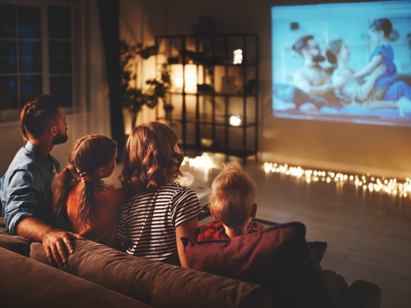 Eine Familie sitzt gemütlich vor dem Fernseher