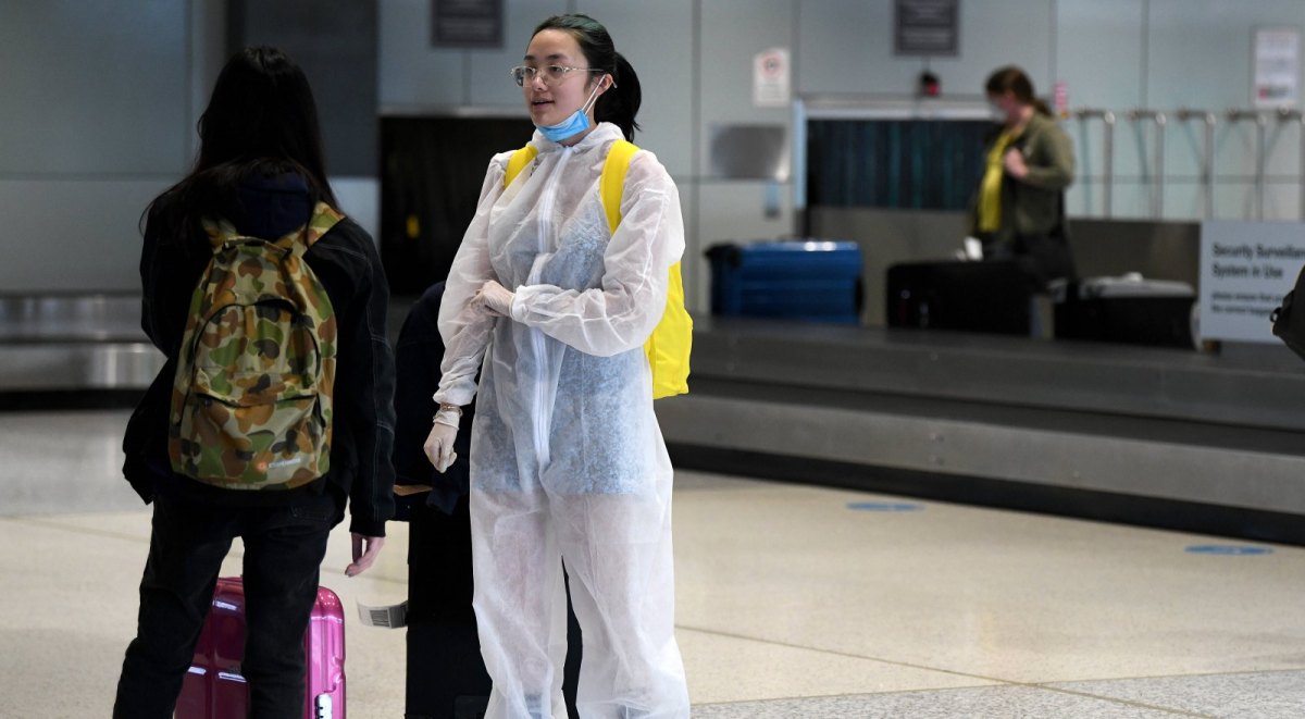 Frau in Schutzanzug am Flughafen