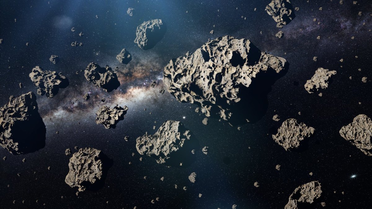 Asteroide vor einer Galaxie.