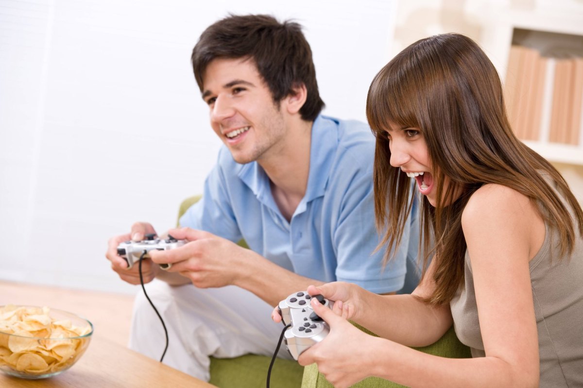 Mann und Frau spielen gemeinsam ein Videospiel mit Controllern in der Hand
