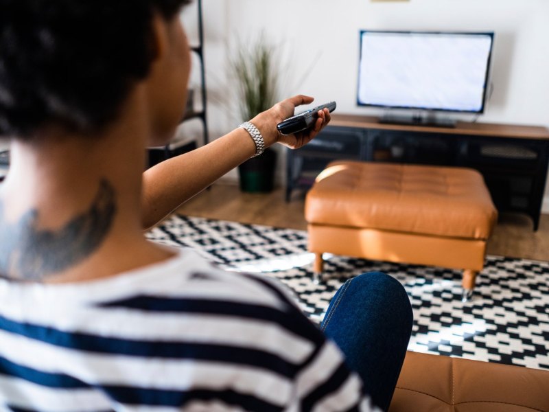 Frau schaltet Fernseher um