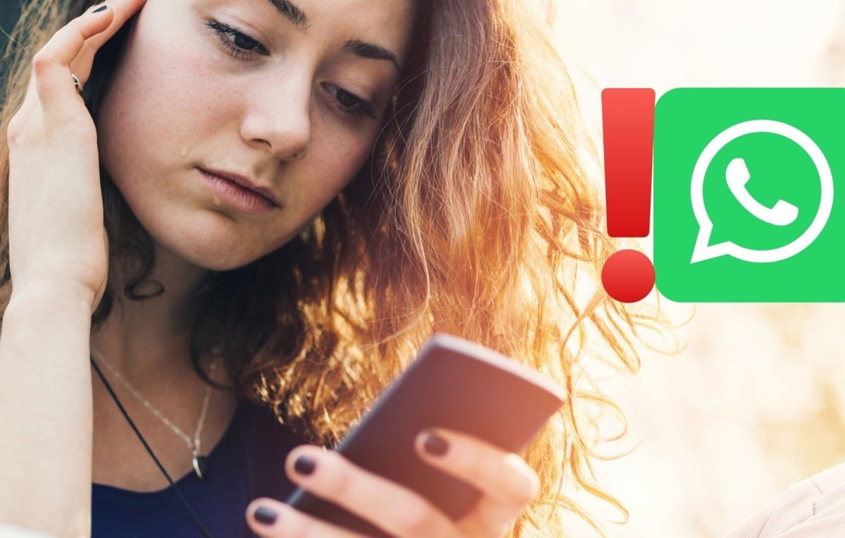 Frau schaut traurig aufs Handy