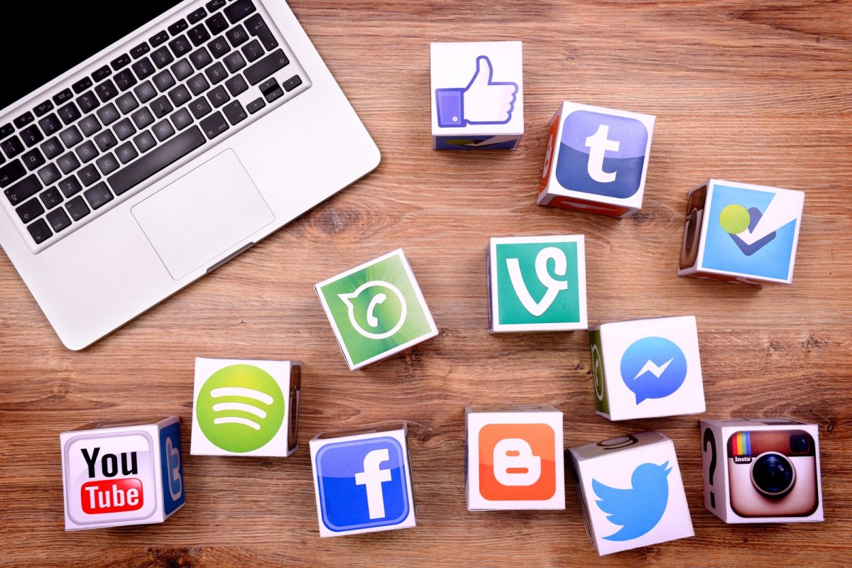 Macbook und verschiedene Logos von Social Media-Plattformen