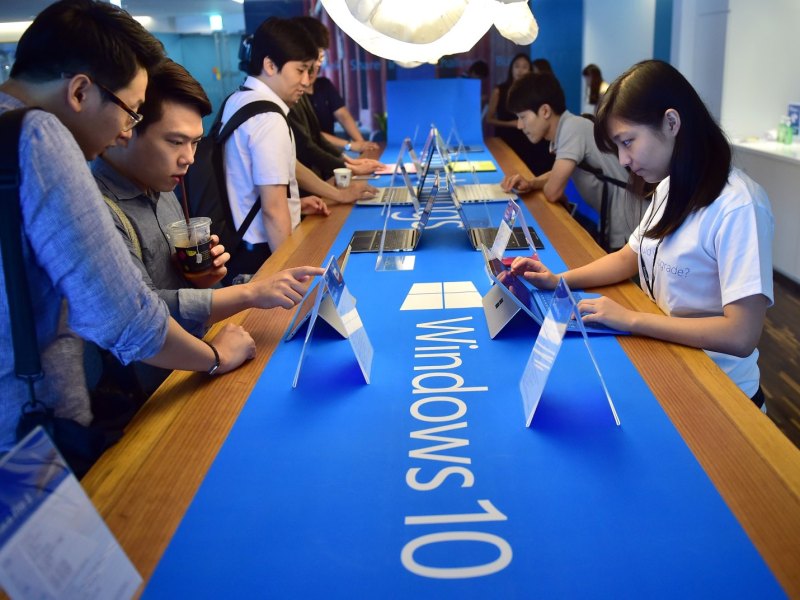 Personen an einem Stand mit Windows 10-Geräten