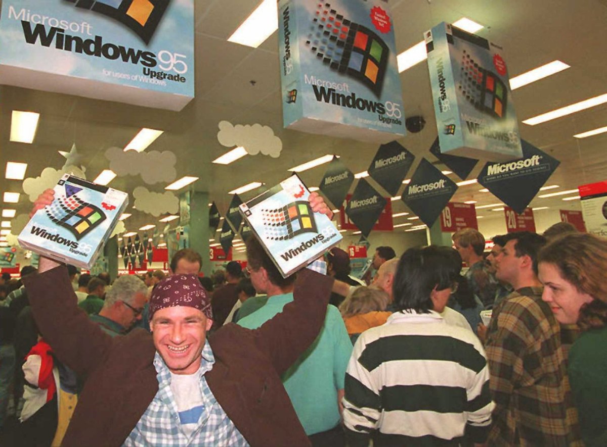 Mann hält Kartons mit Windows 95 hoch