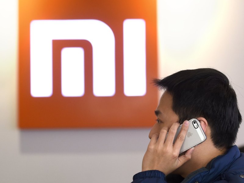 Mann telefoniert vor Xiaomi-Logo