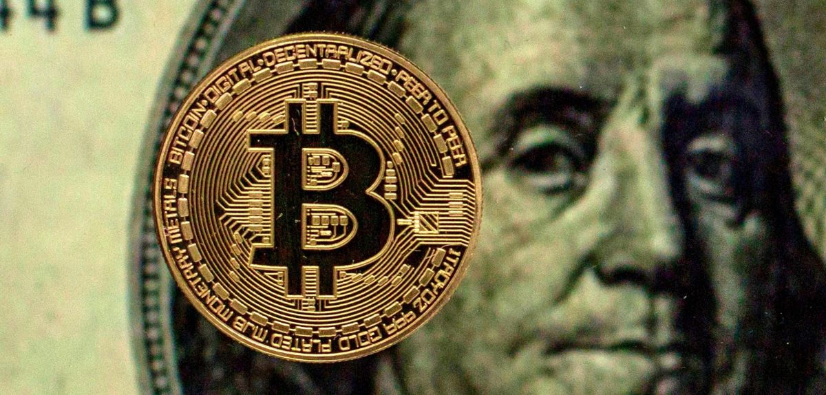 Bitcoin vor einem Dollar-Schein