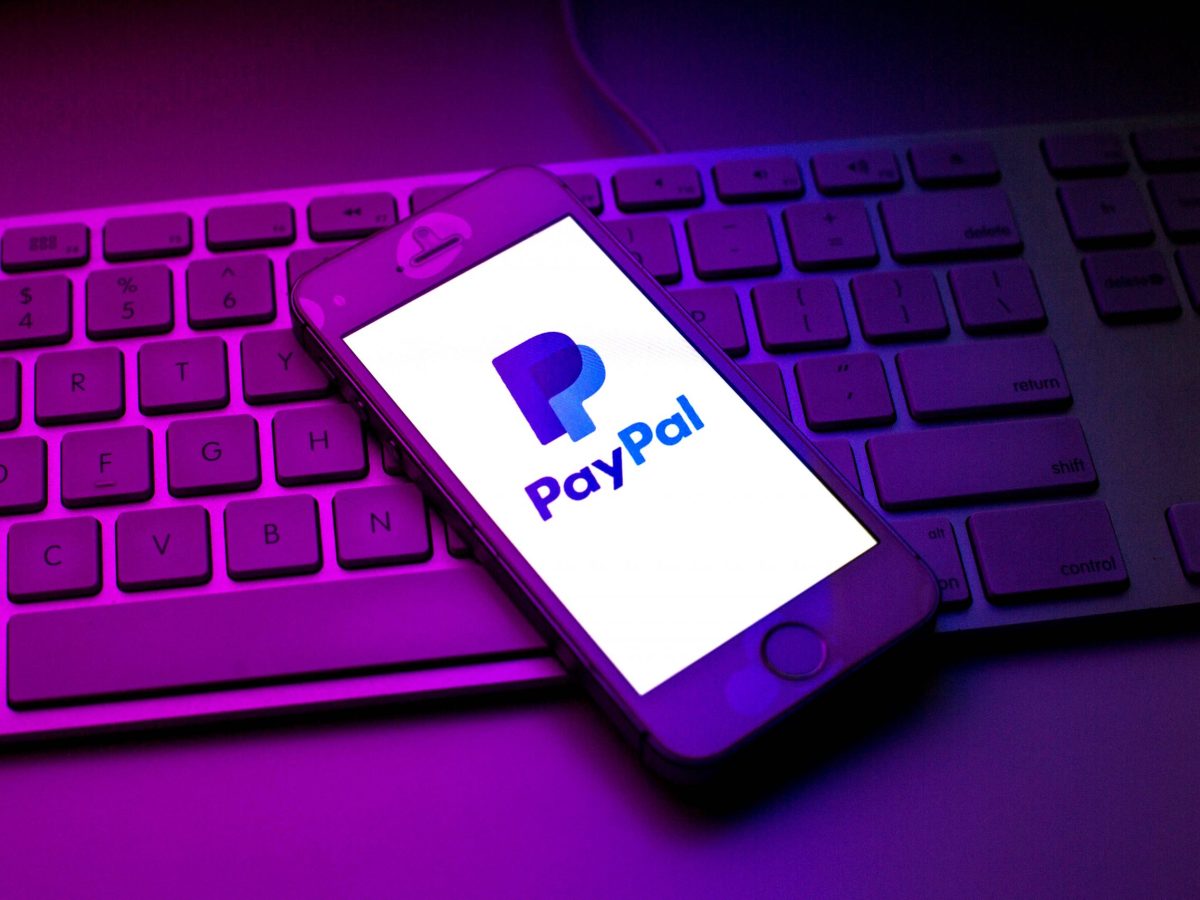 Handy mit PayPal-Logo auf Tastatur liegend