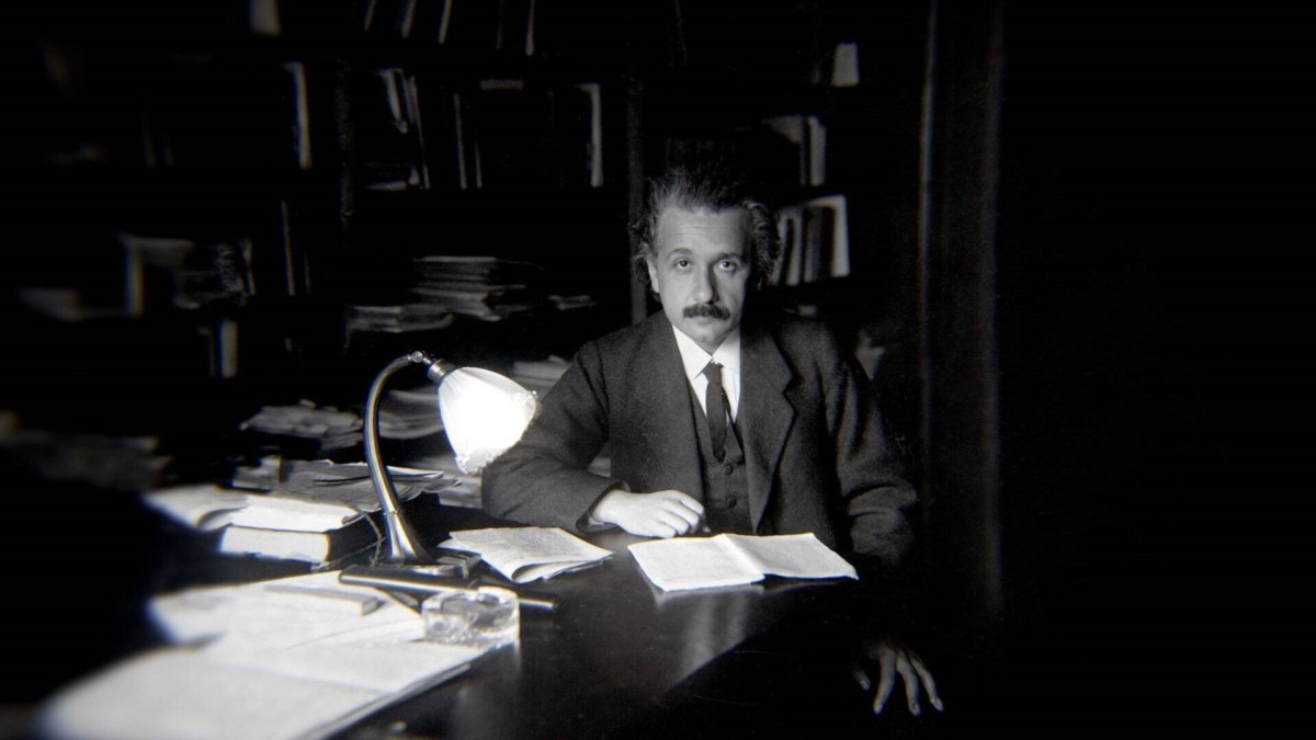 Einstein am Schreibtisch sitzend