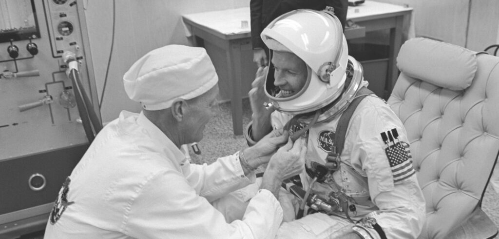 Astronaut L. Gordon Cooper Jr., Gemini-5-Kommandopilot, erhält Hilfe beim Anziehen seines Raumanzugs von NASA-Anzugtechniker Clyde Teague.