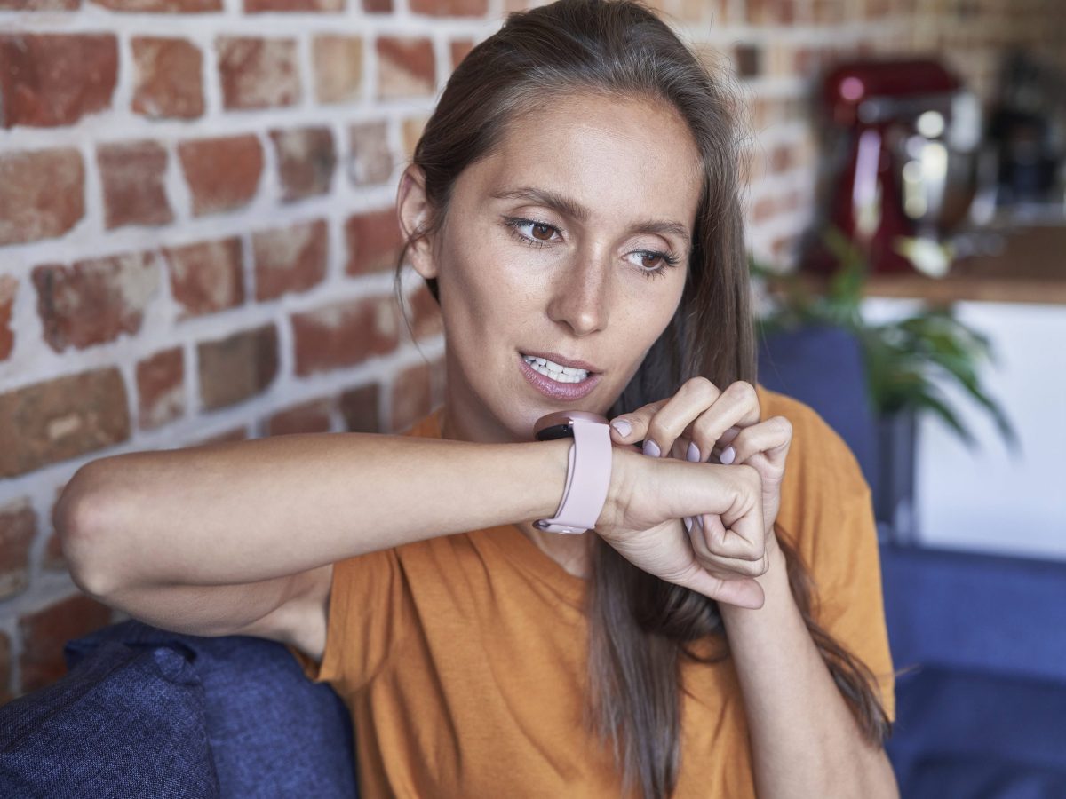 Frau spricht mit Smartwatch