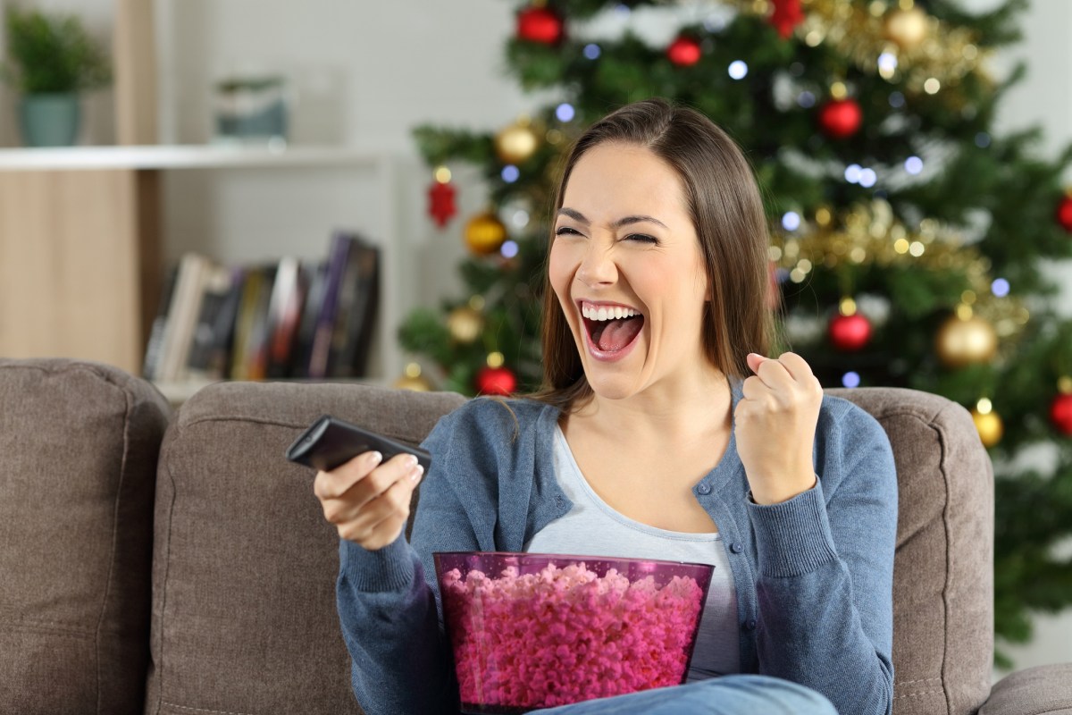 Frau an Weihnachten vor dem Fernseher