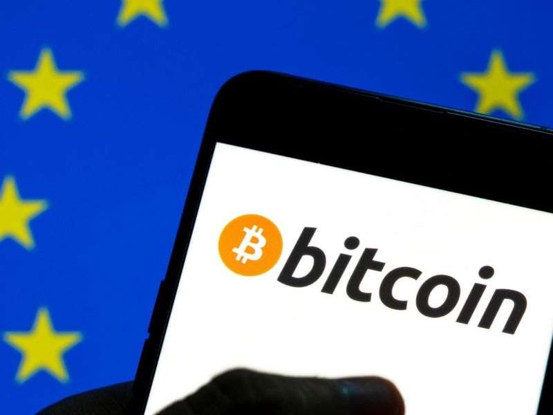 Bitcoin-Logo vor einer EU-Flagge